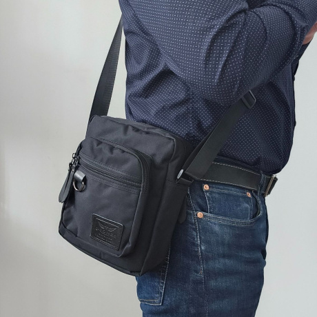 Čierna pánska dvojkomorová crossbody taška so zapínaním na zips.